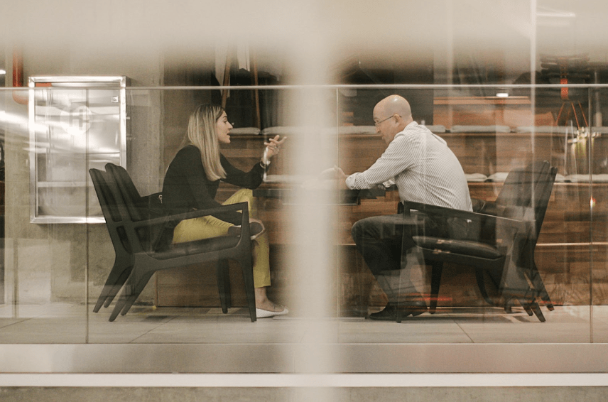 Effective Dialogue: A man and woman holding a conversation behind a glass wall