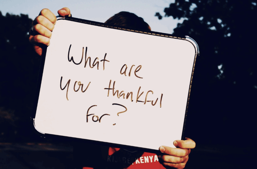 Gratitude: A person holding up a whiteboard with a question