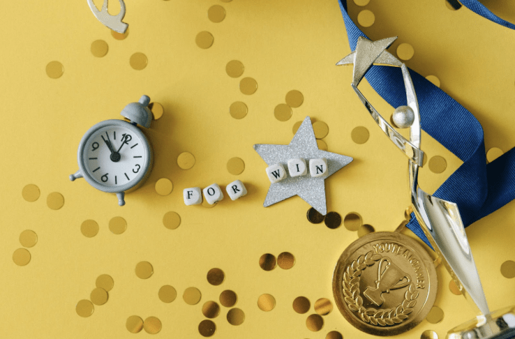 Recognition Systems: A collection of items laid out including a clock, start, and medal.