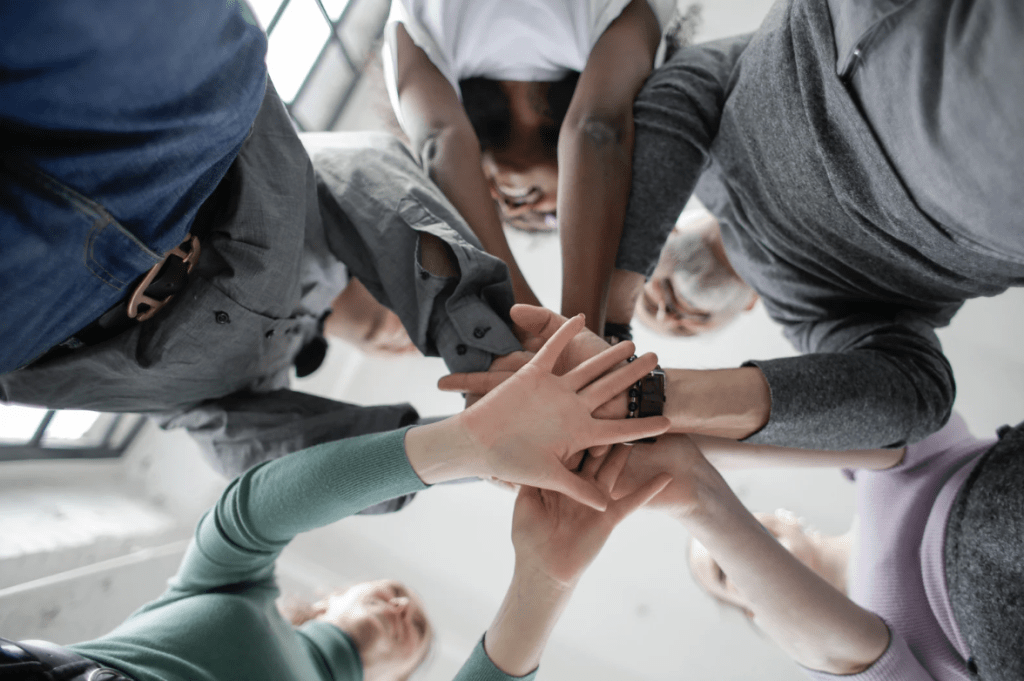 Workplace Resilience: A group of people putting their hands together in a circle.